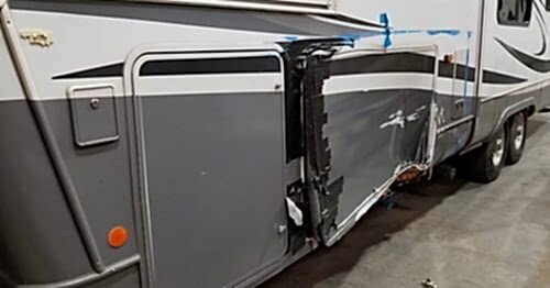Picture showing damage done to the side of an RV from turning into a pole