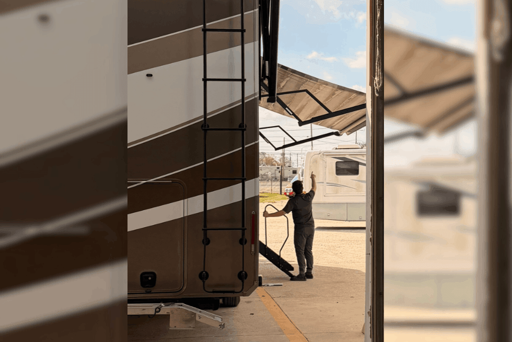 RV safety inspection in LaPlace, LA by RV Masters. Image of a technician opening an RV awning inside a service bay during inspection. Highlighting thorough system checks, structural safety, and reliable performance for worry-free travel.