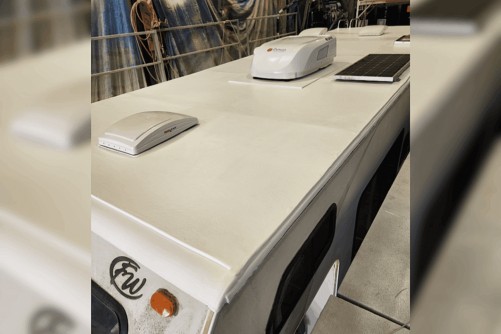 FlexArmor RV roof replacement and repair in LaPlace, LA at RV Masters. Image of an RV roof with rooftop air conditioning units, vents, and a solar panel visible during inspection or maintenance.